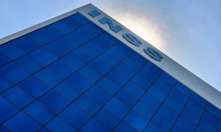 Fachada do edifício do INSS com janelas espelhadas e céu ao fundo
