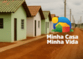 Imagem de casas do programa Minha Casa Minha Vida em uma área no Maranhão, com o logo do programa na parte inferior.