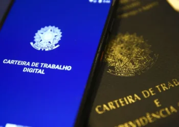 Imagem do celular mostrando a Carteira de Trabalho Digital e a versão física da carteira, simbolizando a conquista de um emprego.