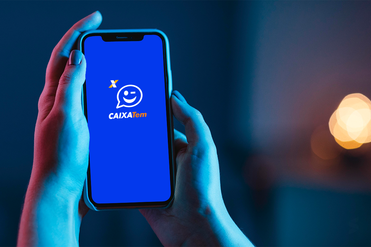 Pessoa segurando celular com a tela do aplicativo Caixa Tem aberta.