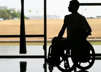 Pessoa em cadeira de rodas refletindo sobre a isenção de IPVA para PCD, destacando a importância da acessibilidade.