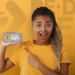 Imagem de uma jovem mostrando celular com o logo do Pé-de-Meia