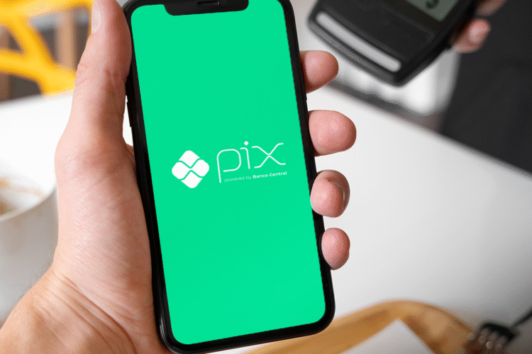 "Tela de smartphone mostrando o logo do PIX com fundo verde. O sistema de pagamento instantâneo do Banco Central.