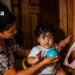 Mulher interagindo com criança pequena, mostrando a importância do Programa Criança Feliz no desenvolvimento infantil.