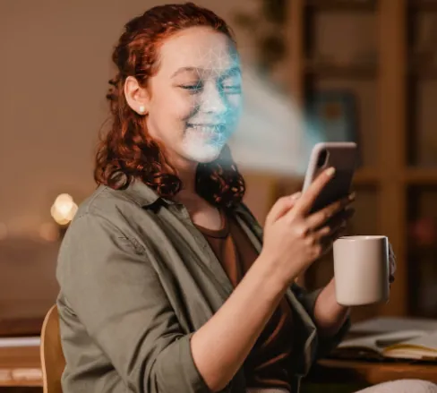 Mulher realizando reconhecimento facial com o celular e sorrindo