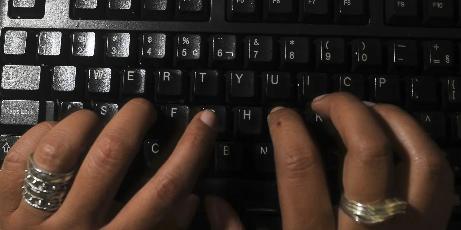 Mãos digitando em teclado de computador para realizar inscrição online