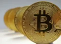 Imagem ilustrativa de uma criptomoeda Bitcoin, representando o conceito de dinheiro digital e transações criptográficas.