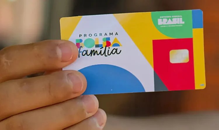 Cartão do Programa Bolsa Família, mostrado em mãos, com cores vibrantes.