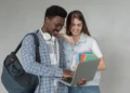 Estudantes com laptop e livros, em momento de interação