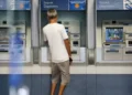 Pessoa utilizando um caixa eletrônico da Caixa Econômica Federal, simbolizando o processo de biometria para acesso à conta.