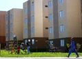 Crianças brincando em área comum de conjunto habitacional popular