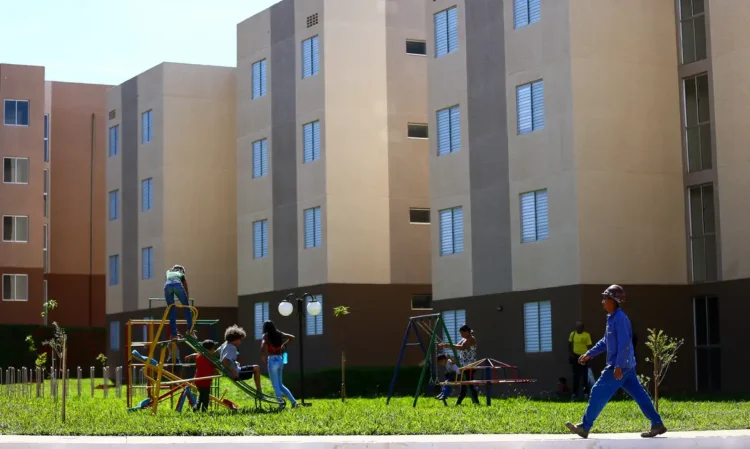 Crianças brincando em área comum de conjunto habitacional popular