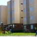 Crianças brincando em área comum de conjunto habitacional popular