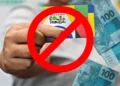Cartão do Bolsa Família com a sobreposição de um símbolo de proibição, representando o bloqueio de benefícios devido a irregularidades nos dados.