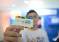 Cartão do programa Pé-de-Meia sendo exibido por um estudante, simbolizando o apoio financeiro para o ensino médio.