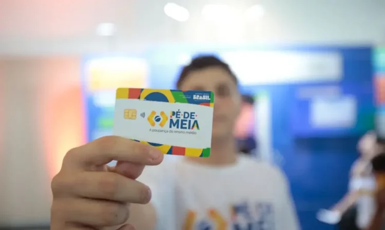 Cartão do programa Pé-de-Meia sendo exibido por um estudante, simbolizando o apoio financeiro para o ensino médio.