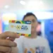 Cartão do programa Pé-de-Meia sendo exibido por um estudante, simbolizando o apoio financeiro para o ensino médio.