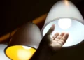 Lâmpadas acesas com luz branca e amarela, representando consumo de energia
