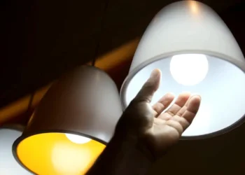 Lâmpadas acesas com luz branca e amarela, representando consumo de energia