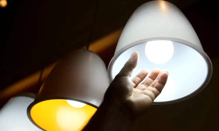 Lâmpadas acesas com luz branca e amarela, representando consumo de energia