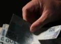 Pessoa segurando cédulas de R$ 100 e R$ 50, ilustrando a oportunidade de crédito para trabalhadores