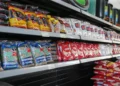 Produtos essenciais como arroz e feijão em prateleiras de supermercado