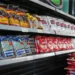 Produtos essenciais como arroz e feijão em prateleiras de supermercado