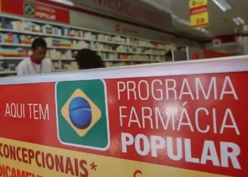 Fachada de farmácia com placa do Programa Farmácia Popular do Brasil.