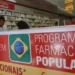 Fachada de farmácia com placa do Programa Farmácia Popular do Brasil.