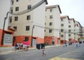 Conjunto habitacional com moradores e crianças em frente aos prédios