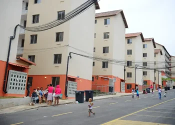 Conjunto habitacional com moradores e crianças em frente aos prédios