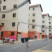 Conjunto habitacional com moradores e crianças em frente aos prédios