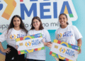 Três jovens sorrindo e segurando cartões do programa Pé de Meia, com a inscrição A poupança do ensino médio.