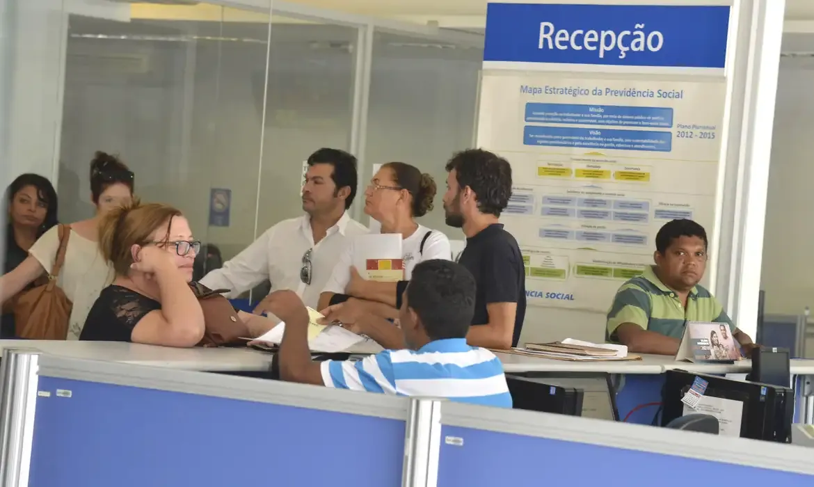 Pessoas aguardando atendimento na recepção de uma agência do INSS