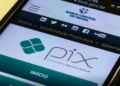 Tela de smartphone mostrando a interface do site do Banco Central do Brasil, com o logo do PIX e informações sobre o sistema de pagamentos instantâneos.