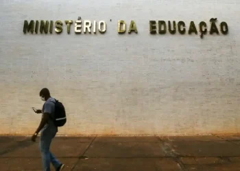 Fachada do Ministério da Educação com pessoa passando em frente