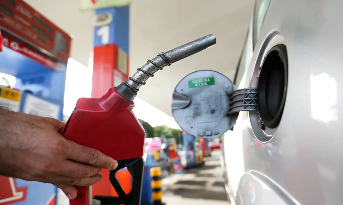 "Posto de combustível abastecendo um carro, representando o horário de funcionamento obrigatório"