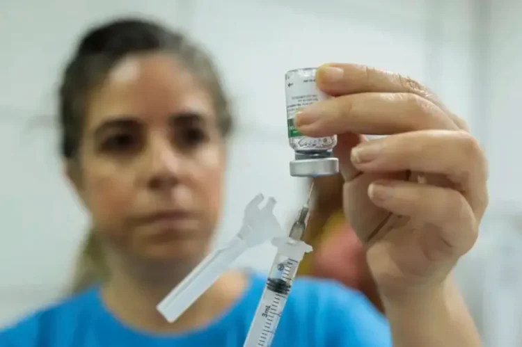 Profissional de saúde prepara vacina contra gripe durante campanha de 2025