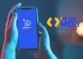 Pessoa segurando celular com aplicativo Caixa Tem aberto ao lado do logo do programa Pé-de-Meia