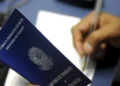 "Carteira de trabalho sendo preenchida, simbolizando a relação entre empregador e trabalhador"