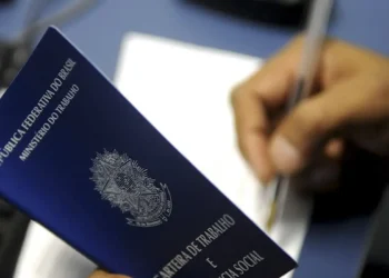 "Carteira de trabalho sendo preenchida, simbolizando a relação entre empregador e trabalhador"