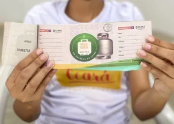 Beneficiário segurando o cartão do Vale Gás Social, emitido pelo Governo do Estado, com os dados visíveis.