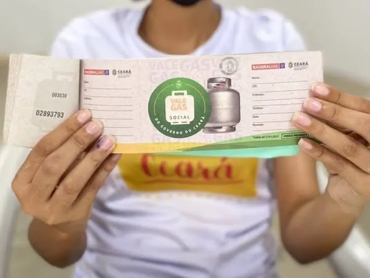 Beneficiário segurando o cartão do Vale Gás Social, emitido pelo Governo do Estado, com os dados visíveis.