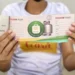 Beneficiário segurando o cartão do Vale Gás Social, emitido pelo Governo do Estado, com os dados visíveis.