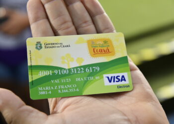 Pessoa segurando o Cartão Mais Infância Ceará usado para recebimento de benefício social