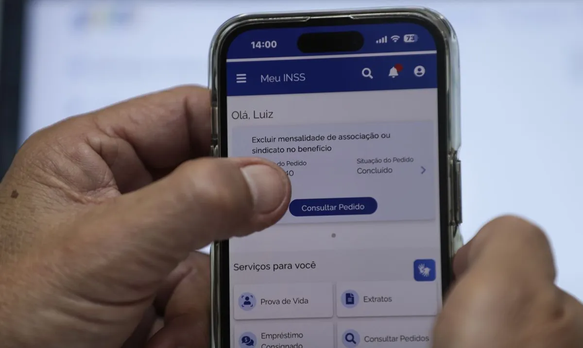 Pessoa utilizando o aplicativo Meu INSS no celular para consultar um pedido de benefício