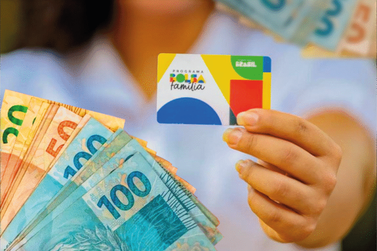 Cartão do Bolsa Família sendo exibido ao lado de cédulas de real