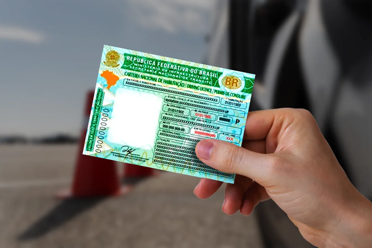 Pessoa segurando a Carteira Nacional de Habilitação (CNH) brasileira com fundo desfocado