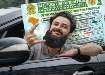 Homem sorrindo e mostrando a CNH Social com fundo do carro.
