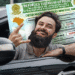 Homem sorrindo e mostrando a CNH Social com fundo do carro.